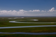The magnificent river that snakes along a vast grassland.